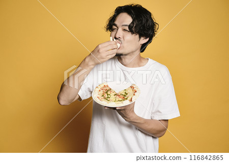 彩色背景的男人吃披薩 彩色背景的男人吃披薩 116842865