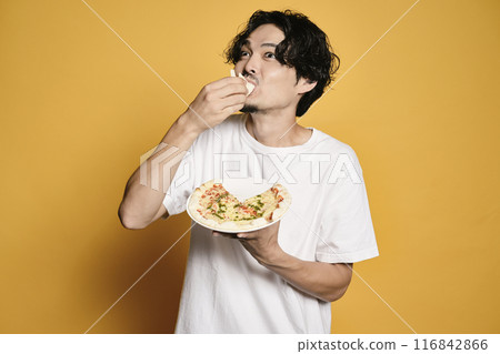 彩色背景的男人吃披薩 彩色背景的男人吃披薩 116842866