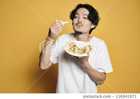 彩色背景的男人吃披薩 彩色背景的男人吃披薩 116842871