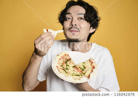 彩色背景的男人吃披薩 彩色背景的男人吃披薩 116842876