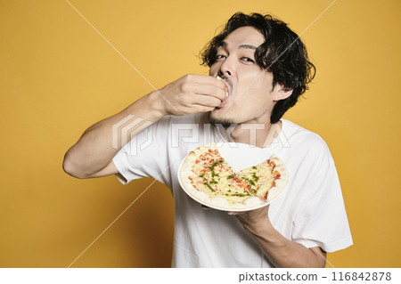 彩色背景的男人吃披薩 彩色背景的男人吃披薩 116842878