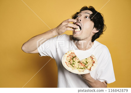 A man eating pizza on a color background 116842879
