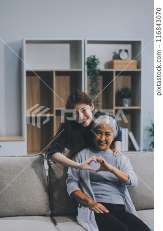 Adult daughter old mom hugging sit on couch enjoy pleasant positive talk, remembering funny occasion from life spend weekend together, caring about older generation relatives express attention concept 116843070