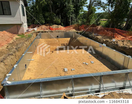 Construction of steel structure for swimming pool near house is in progress Construction of steel structure for swimming pool near house is in progress 116843318