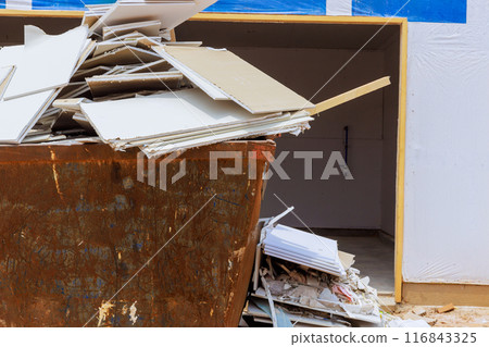 As drywall chunks were being disposed of, they were placed in container for construction waste. As drywall chunks were being disposed of, they were placed in container for construction waste. 116843325