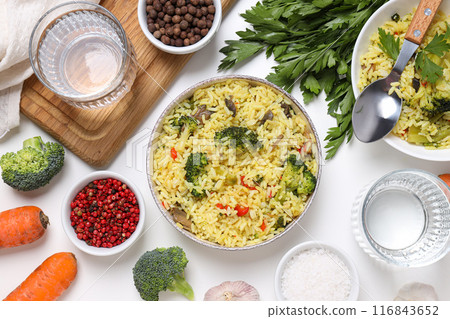 Pilaf, spices, vegetables and glasses of water on white background, top view 116843652
