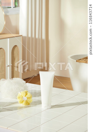 Bathroom concept photo for advertise product of cosmetic or beauty care, a blank label tube placed on the white table top, next to two bath sponges. Empty space for designing and advertising Bathroom concept photo for advertise product of cosmetic or beauty care, a blank label tube placed on the white table top, next to two bath sponges. Empty space for designing and advertising 116843714