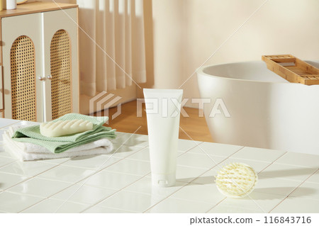 Mock up for promotional with a white cosmetic tube without label placed on white bathroom table, in back is some bathroom stocks like tub and cabinet. Empty space for advertising and adding text 116843716