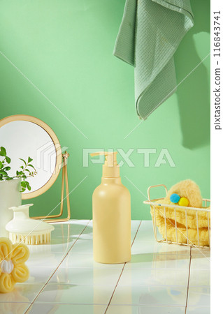 Bathroom theme advertising photography with green and yellow color tone, a yellow high pump bottle displayed on a bathroom floor, next to a mesh basket, a table mirror, brush and a tree pot Bathroom theme advertising photography with green and yellow color tone, a yellow high pump bottle displayed on a bathroom floor, next to a mesh basket, a table mirror, brush and a tree pot 116843741
