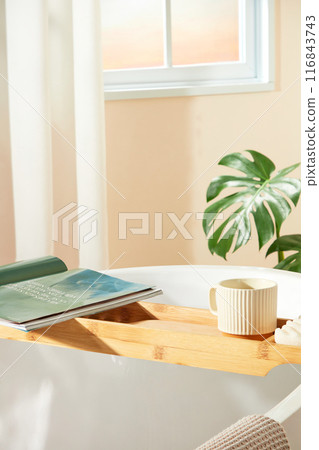 Hygiene products advertising photo with lifestyle, was shot from above view at a bath tub placed by the window. A wooden tray with some casual life stocks above, blank space for displaying 116843743