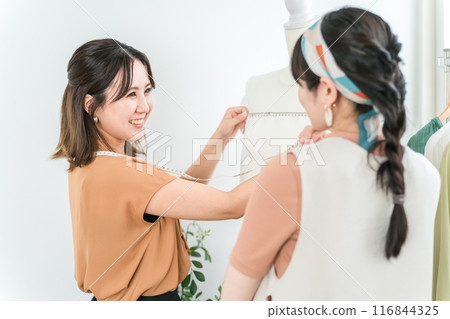 Asian woman of a tailor or seamstress measuring and measuring with a tape measure 116844325