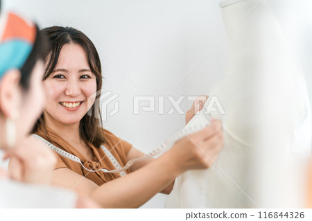 Asian woman of a tailor or seamstress measuring and measuring with a tape measure 116844326