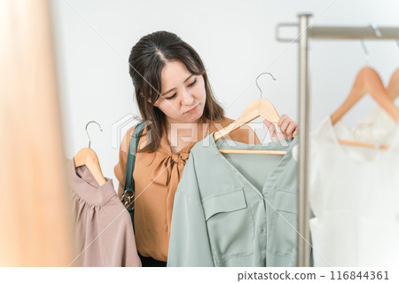 A woman choosing clothes at a house, a clothing store, an apparel shop (fashion shopping) 116844361