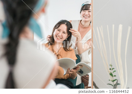 Hairdresser / stylist counseling with Asian female customer who consults hairstyle at beauty salon / hair salon 116844452