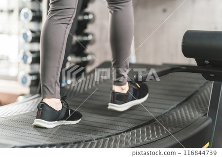 Asian woman doing walking and aerobic exercise using a treadmill/running machine at a sports gym 116844739