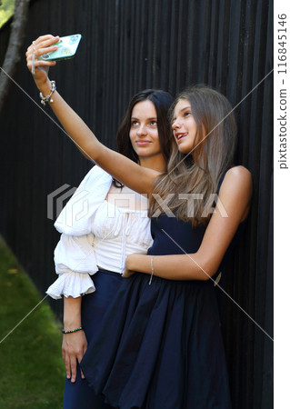 Two teenage girls are friends. Teenage girls posing for a photographer. Young and beautiful teenage girls are girlfriends. Teenage girls are friends. Two teenage girls are friends. Teenage girls posing for a photographer. Young and beautiful teenage girls are girlfriends. Teenage girls are friends. 116845146