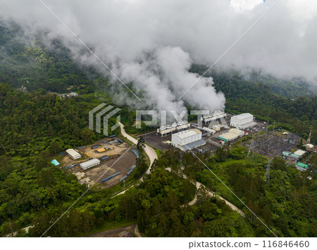 Geothermal station with steam and pipes. Renewable energy production at a power station. Mindanao, Philippines. Top view survey. Geothermal station with steam and pipes. Renewable energy production at a power station. Mindanao, Philippines. Top view survey. 116846460