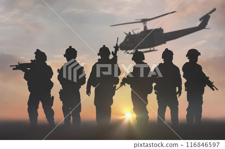 silhouette of military special force unit with helicopter in the background under sunset sky 116846597