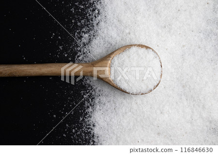 salt in wooden spoon on black background 116846630