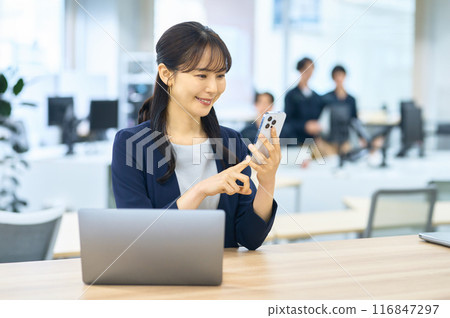 操作一個智能手機的少婦在辦公室 116847297