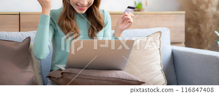 Young asian woman sitting on sofa using laptop computer shopping online with credit card. Young asian woman sitting on sofa using laptop computer shopping online with credit card. 116847408