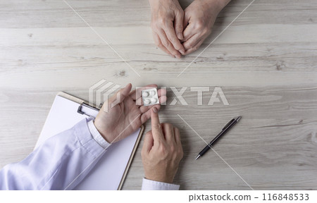 A doctor or pharmacist explaining medication to an elderly person A doctor or pharmacist explaining medication to an elderly person 116848533
