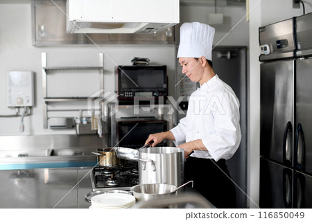 Young asian male chef preparing food in the kitchen Young asian male chef preparing food in the kitchen 116850049