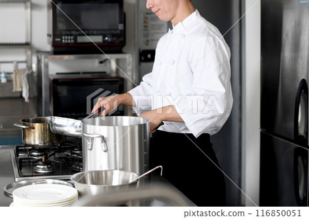 Young asian male chef preparing food in the kitchen Young asian male chef preparing food in the kitchen 116850051