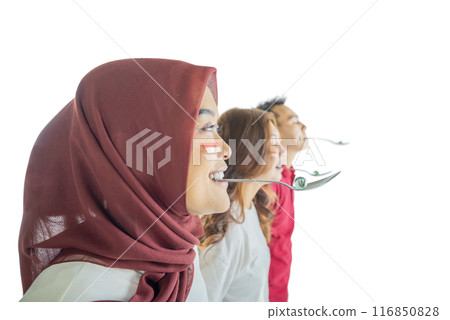 Three people with spoons are marble racing, one of them is wearing a red scarf Three people with spoons are marble racing, one of them is wearing a red scarf 116850828