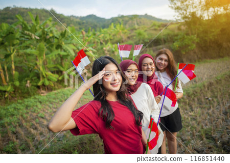 Portrait group of Indonesian women with excited expressions holding small Indonesian flag 116851440