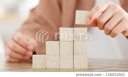 A man stacking building blocks 116852081