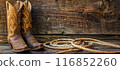 Fancy cowgirl boots with a cowboy hat and lasso rope background a wooden wall 116852260