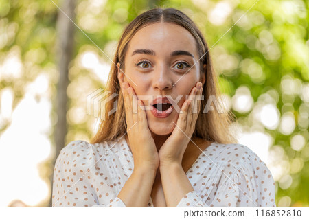 Woman looking surprised at camera with big open eyes, shocked by sudden victory good news wow win Woman looking surprised at camera with big open eyes, shocked by sudden victory good news wow win 116852810