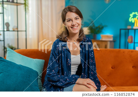 Portrait of happy calm Caucasian woman at home couch smiling friendly, looking at camera resting 116852874