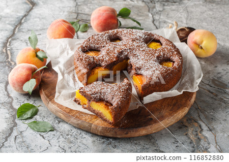 Fruit chocolate peach sponge cake summer dessert close-up on wooden board. Horizontal Fruit chocolate peach sponge cake summer dessert close-up on wooden board. Horizontal 116852880