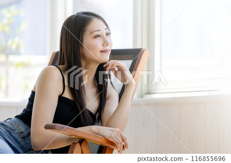 坐在窗邊椅子上的年輕女子 坐在窗邊椅子上的年輕女子 116855696