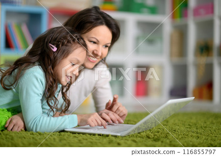 Happy laughing mother and little cute daughter using laptop 116855797