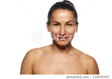 Portrait of beautiful woman with bare shoulders looking with smile at camera against white studio background. Model without make-up. Portrait of beautiful woman with bare shoulders looking with smile at camera against white studio background. Model without make-up. 116856487