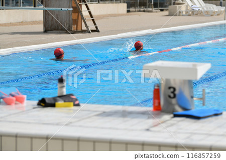 Swimmers wearing silicone caps swim in a pool Swimmers wearing silicone caps swim in a pool 116857259