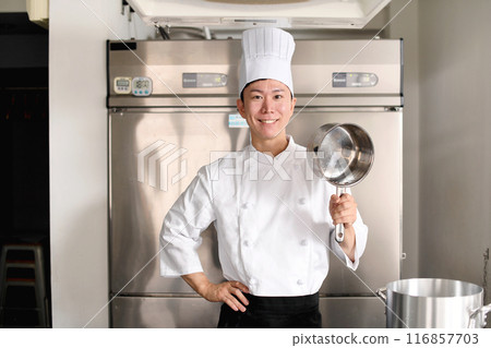 Young asian male chef preparing food in the kitchen Young asian male chef preparing food in the kitchen 116857703
