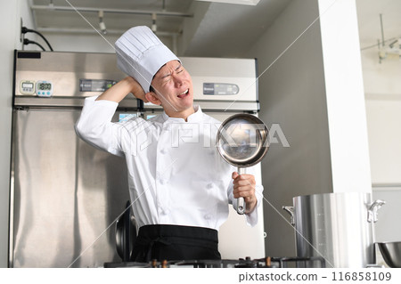 Young Asian male chef worried in the kitchen Young Asian male chef worried in the kitchen 116858109