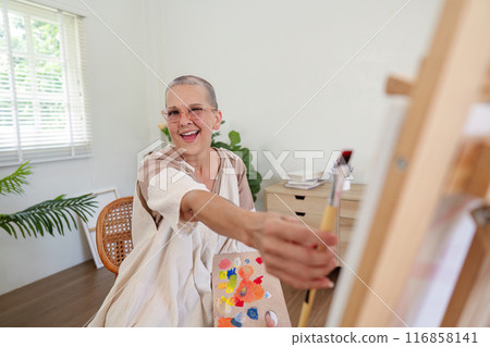 Attractive old woman painting at home. Inspirational hobby and art therapy Attractive old woman painting at home. Inspirational hobby and art therapy 116858141