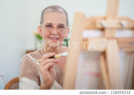 Senior woman painting on canvas at home, Elderly woman painting on a canvas, Happy retirement concepts Senior woman painting on canvas at home, Elderly woman painting on a canvas, Happy retirement concepts 116858142