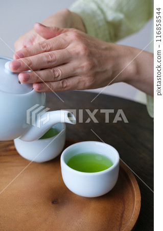 A middle-aged woman preparing tea for guests 116858544