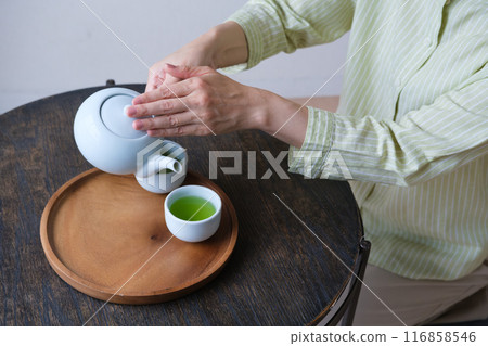 A middle-aged woman preparing tea for guests 116858546