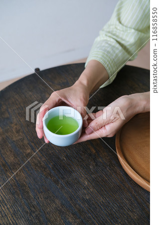 A middle-aged woman preparing tea for guests 116858550