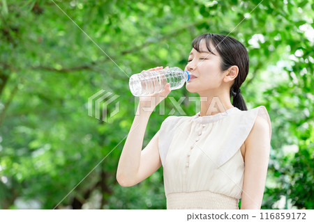 一位女士在新鮮的綠色植物中補充水分 116859172