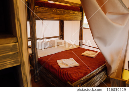 Interior of cozy open glamping tent. Camping tent for outdoor summer holiday and vacation Interior of cozy open glamping tent. Camping tent for outdoor summer holiday and vacation 116859329