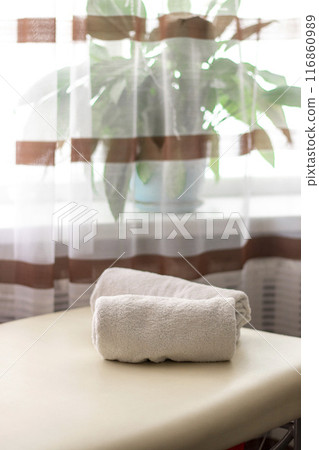 Close up shot of the white towels rolled in the massage couch. 116860989