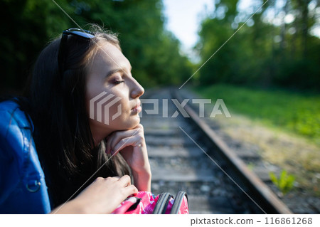 During long journeys on foot along the tracks, the teenager decided to sit down and rest directly on the railway track. 116861268